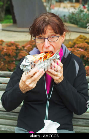 Frau Essen ungesunde Fertigkost Stockfoto