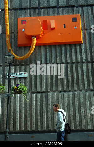 Niedrigen Winkel Blick auf einen riesigen Strom-Stecker und eine Buchse auf eine Wand, Ganton Street, Soho, London, England Stockfoto