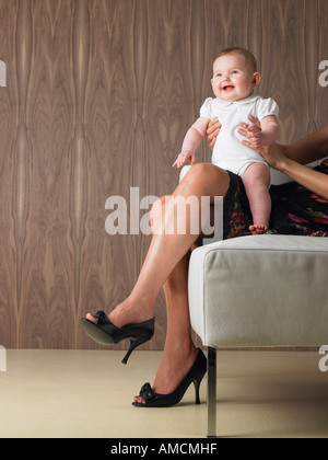 Babysitter auf Mutters Schoß Stockfoto