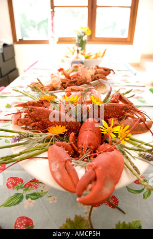 Verschwenderische Meeresfrüchte Teller Langusten, Seespinnen und Hummer, mit sortierten Blumen auf einem Tisch in einer häuslichen Umgebung eingerichtet Stockfoto