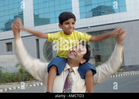 Indian Executive Vater spielt mit Sohn auf seinen Schultern, MR#637 & 560 Stockfoto