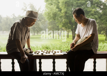 Zwei Männer sitzen im Freien spielen Brettspiel Stockfoto