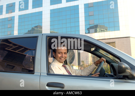VEP72172 junge indische Executive mit Krawatte lächelnd und Autofahren Stockfoto