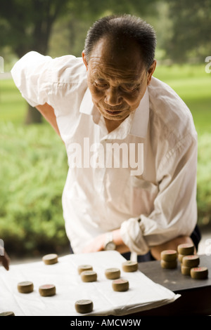 Mann steht über Brettspiel im freien Konzentration Stockfoto