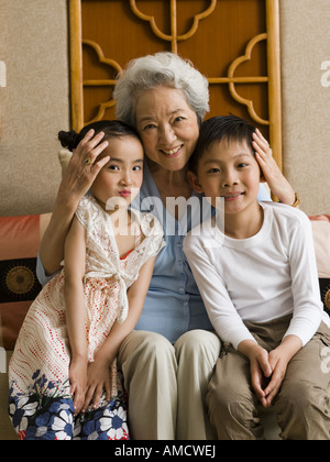 Oma mit Enkelin und Enkel lächelnd Stockfoto