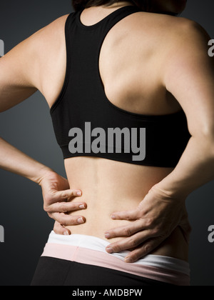 Rückansicht des Frau mit Hände am unteren Rücken Stockfoto