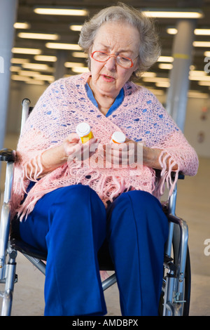 Blick auf eine senior Frau im Rollstuhl mit Medikamenten. Stockfoto
