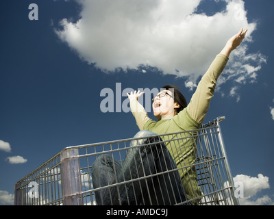 Mann mit Brille im Warenkorb im Freien mit Arme nach oben lächelnd Stockfoto