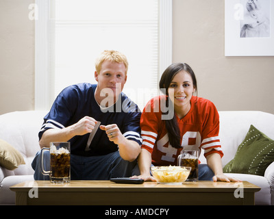 Mann und Frau auf dem Sofa vor dem Fernseher Stockfoto