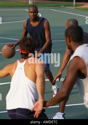 Vier Männer spielen Basketball im freien Stockfoto