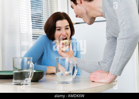 Blick auf eine Mitte erwachsenes paar Muffin am Esstisch Essen. Stockfoto
