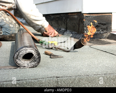 Dachdecker auf Knien neue Bitumen schneiden fühlte sich auf Größe auf 'flach' Garagendach, Roll von Blei blinken & Gasbrenner (als Ersatz für alte Filz) Stockfoto