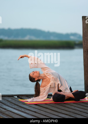 Frau tut Yoga am frühen Morgen auf Dock Virginia Beach, VA Stockfoto