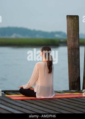 Frau tut Yoga am frühen Morgen auf Dock Virginia Beach, VA Stockfoto