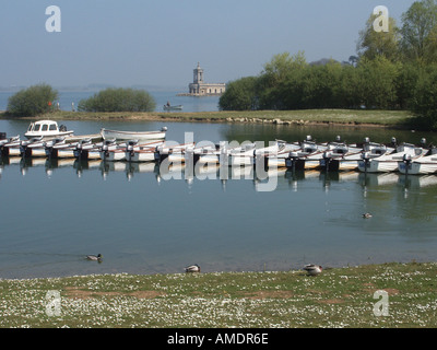 Anglian Water kleine Motorboot mieten Einrichtung auf Rutland Water Trinkwasserspeicher Mann in Angeln Boot & Normanton Kirche entfernt in der Landschaft UK Stockfoto