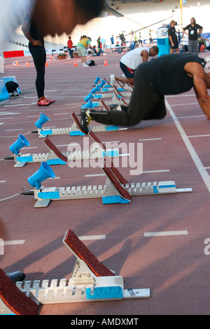 Männer verfolgen Sprinter Aufwärmen vor dem Rennen am Ausgangspunkt Stockfoto