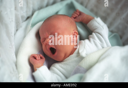 Neugeborenes Babymädchen 4 Wochen alt, schläft in einem Kinderwagen Gähnen Stockfoto