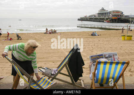 Eine ältere Frau legt ihr Liegestuhl am Meer, Bournemouth, Dorset, Großbritannien. September 2006. Stockfoto