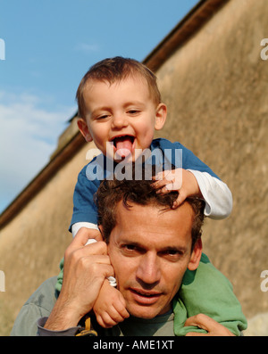 Glücklicher Vater und Sohn gemeinsam draußen in der Sonne spielen Stockfoto