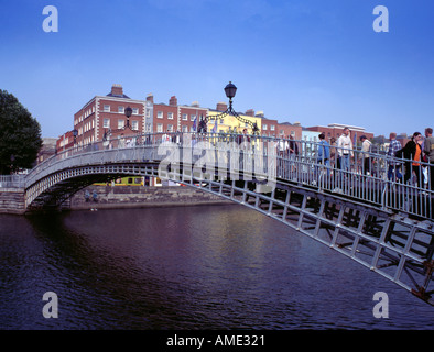 Menschen über das malerische Gusseisen Ha'penny Brücke über den Fluss Liffey, Temple Bar Gegend, Dublin, Eire (Irland). Stockfoto