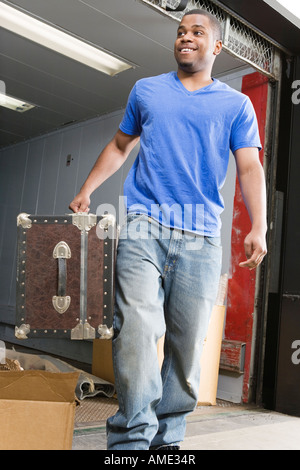 Junger Mann mit Koffer und lächelnd. Stockfoto
