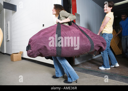 Junge Frau, die eine riesige Reisetasche. Stockfoto