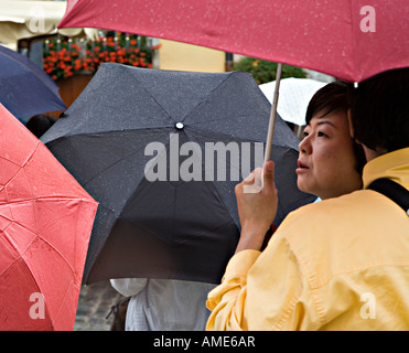 Orientalische Frau Gruppe von Touristen mit Sonnenschirmen im Regen Rothenburg Deutschland Stockfoto