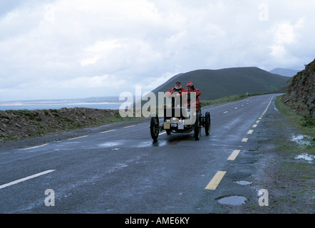 Elderrly paar fahren einen offenen Oldtimer entlang der Ring of Kerry in Irland im strömenden Regen Stockfoto