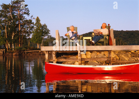 Reifen Sie paar lesen Zeitungen im Dock Stockfoto