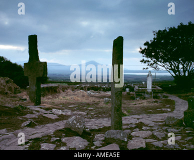 Alte Platte Kreuz und Ogham-Stein, Kilmalkedar Friedhof, in der Nähe Ballynana, Halbinsel Dingle, County Kerry, Eire (Irland). Stockfoto