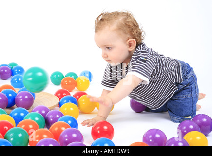 Kleiner Junge spielt mit farbigen Kugeln, Deutschland Stockfoto