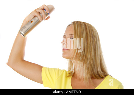 Junge, blonde Frau, ihr Haar mit Haarspray fixieren Stockfoto