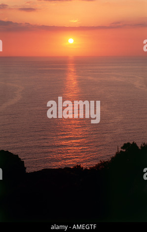 Die Einstellung Sonne fallen unter den Horizont betrachtet in der Nähe der Ortschaft Nonza auf einem Hügel mit Blick auf das Wasser des Golfe de St Florent am Cap Corse Stockfoto