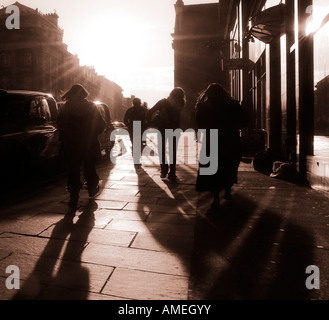 Fußgänger zu Fuß bergauf, in einer Stadt, die Straße in Richtung der Sonne Edinburgh Schottland UK GB Stockfoto