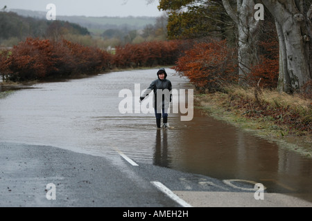 Frau waten durch Hochwasser des Flusses Deveron auf dem B9025 in der Nähe von Turriff, Aberdeenshire, Schottland nach starkem Regen Stockfoto