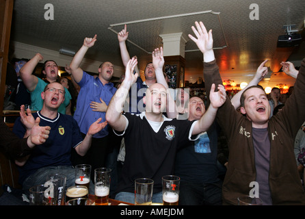 Schottische Fußball-Fans jubeln mit Emotion, wie sie ihr Team-Spiel im Fernsehen in einem Pub in Aberdeen, Schottland, UK zu sehen Stockfoto