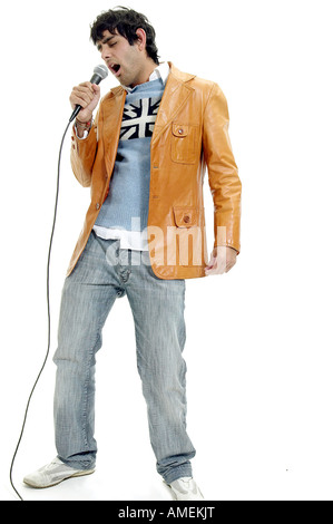 Junger Mann ins Mikrofon singen Stockfoto