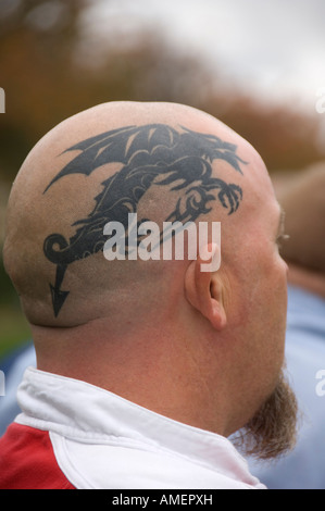 Bald leitete walisische Mann mit Staatswappen der Wales - eine stilisierte walisischen Drachen-Tattoo auf seinem rasierten Kopf Stockfoto