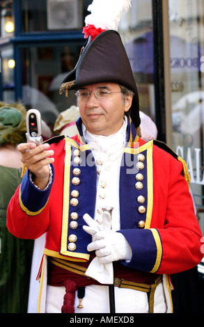 Georgische Trachtenumzug, der Jane Austen Festival in Bath England UK GB Mann in Militäruniform mit Handy starten Stockfoto