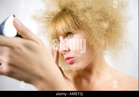 Junge Frau mit krauses Frisur Make UP anwenden Stockfoto