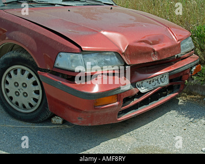 beschädigtes Auto nach einem Unfall gebrochen Motorhaube und vordere Teil des Motors am Straßenrand stehen Stockfoto