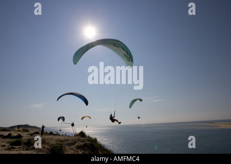 Gleitschirme Silhouette gegen Abend die Sonne über der Bucht von Arcachon, südlich von Bordeaux Frankreich Stockfoto