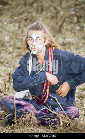 Mann sitzt auf dem Boden, gekleidet wie ein Hippie, England Stockfoto