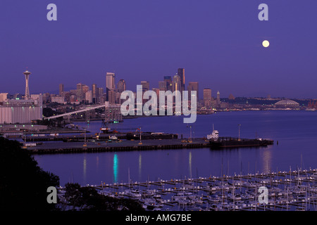 Vollmond steigt über Skyline von Seattle Washington bei Dämmerung Elliot Bay Marina und den Puget Sound im Vordergrund Stockfoto