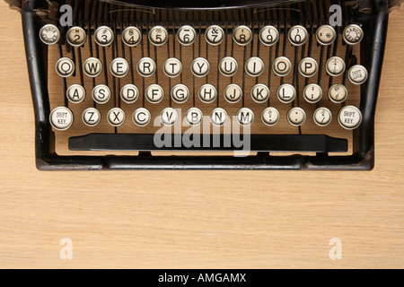 Retro-Schreibmaschine mit QWERTY-Tastatur auf einem Schreibtisch aus Holz Stockfoto