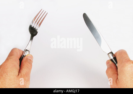 Mann hält eine Tabelle Messer und eine Gabel hautnah Stockfoto