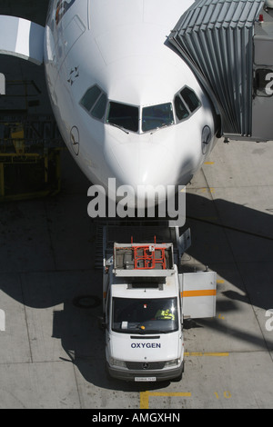 Sauerstoff Lkw Verstärkung eines geparkten Airliner im Tor. Detailansicht der vorderen Partie. Stockfoto