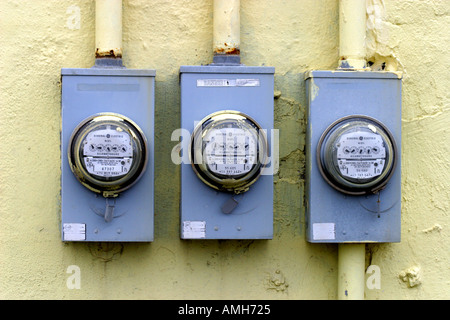 Drei Stromzähler auf eine gelbe Wand Stockfoto