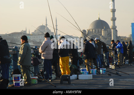 ISTANBUL-Linie Fischen am Goldenen Horn von der Galata-Brücke, mit der (neuen) Yeni-Moschee hinter. 2007. Stockfoto