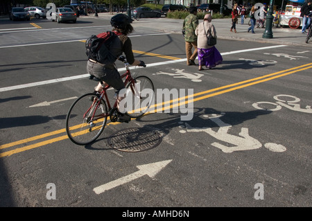 Ein Radfahrer überquert eine Kreuzung auf der Westseite Bikepath markiert für Fahrräder und Inlineskater Stockfoto